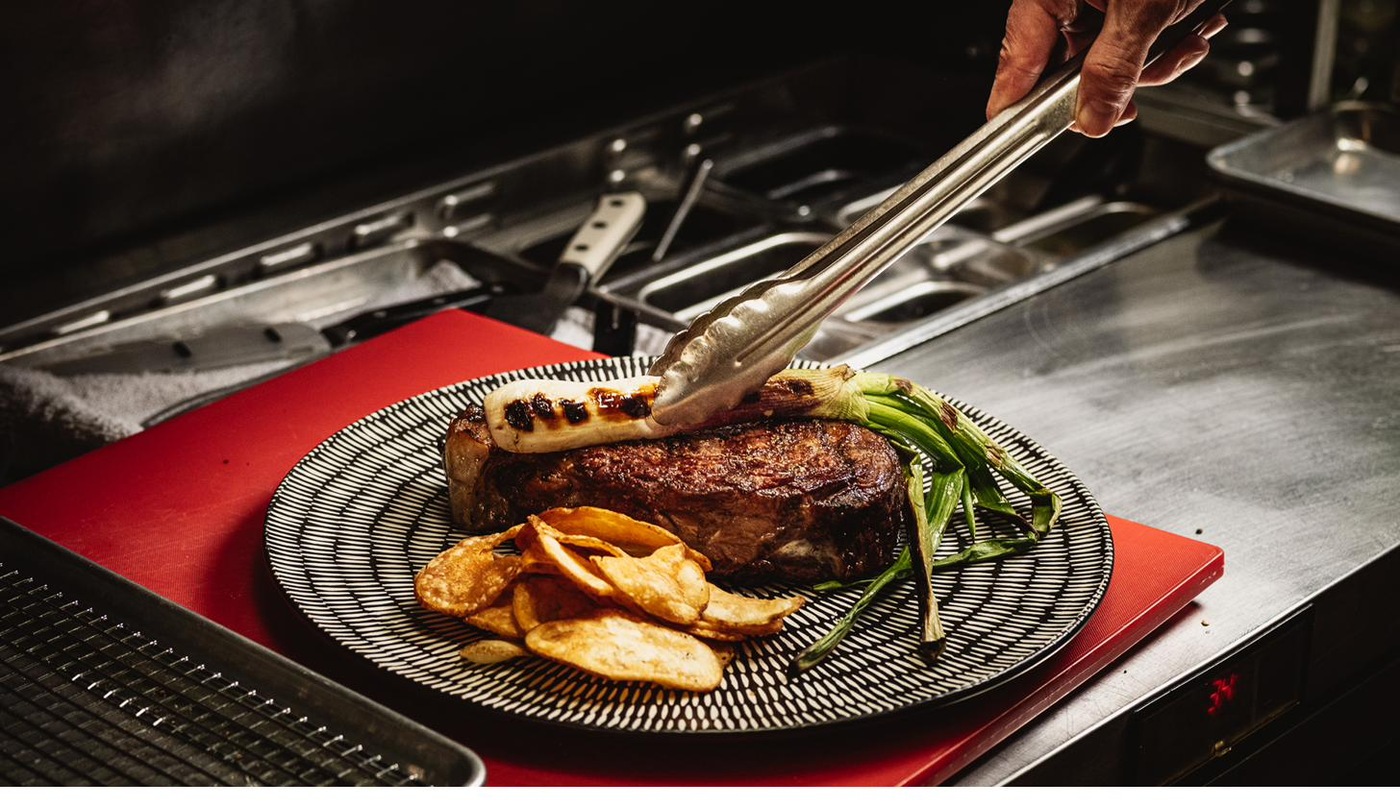 Hayworth dry-aged ribeye plated with tongs in the kitchen — Henderson, NV