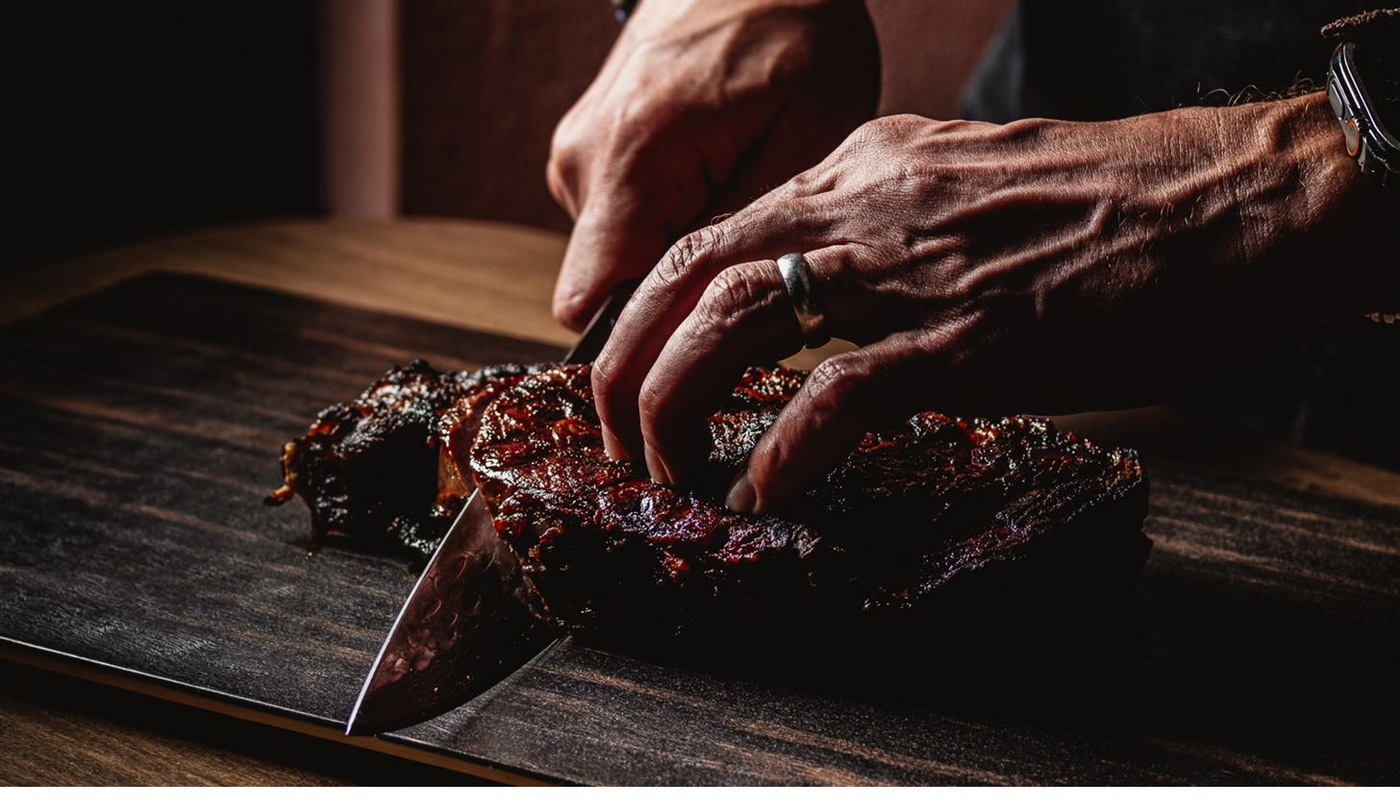 Chef hand-cutting dry-aged steak with a Japanese knife at Hayworth — Henderson, NV